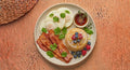 All American — egg whites with crisp turkey bacon and a stack of mini buttermilk pancakes with fresh berries and a side cup of syrup