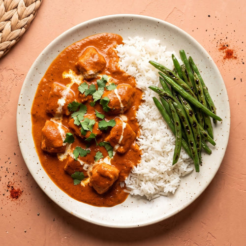 Bombay — halal chicken breast in a creamy tomato butter masala with cilantro, served with jasmine rice and charred green beans