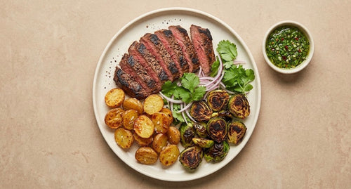 Buenos Aires - sliced grass-fed skirt steak with crispy baby potatoes, charred Brussels sprouts and chimichurri
