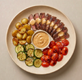 Capri — seared steak in creamy Cajun Alfredo with golden potatoes, zucchini, and grape tomatoes on a cream plate