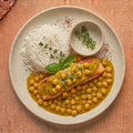 Coconut Curry Salmon — seared wild-caught salmon in golden coconut curry with chickpeas and fresh thyme, served with jasmine rice