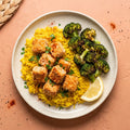 Salmon Bites — panko-crusted wild-caught salmon bites over yellow rice with roasted broccoli and a lemon wedge